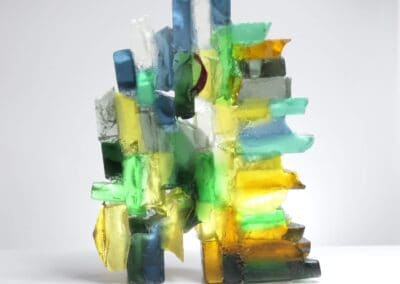 Handmade glass sculpture in blues, yellows and greens and formed as a harbour wall