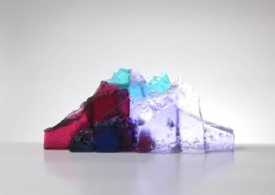 Handmade glass sculpture in the form of a fallen wall in clear, aqua, red and lilac