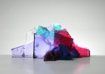 Handmade glass sculpture in the form of a fallen wall in clear, aqua, red and lilac