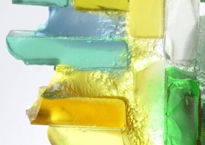 Handmade glass sculpture in blues, yellows and greens and formed as a harbour wall