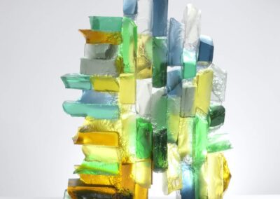 Handmade glass sculpture in blues, yellows and greens and formed as a harbour wall