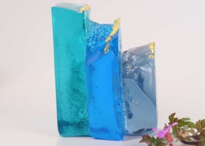 Handmade glass sculpture in the form of a fallen wall in light and dark blue with gold leaf