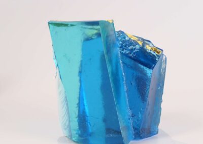 Handmade glass sculpture in the form of a fallen wall in light and dark blue with gold leaf