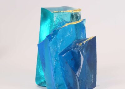 Handmade glass sculpture in the form of a fallen wall in light and dark blue with gold leaf