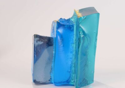 Handmade glass sculpture in the form of a fallen wall in light and dark blue with gold leaf