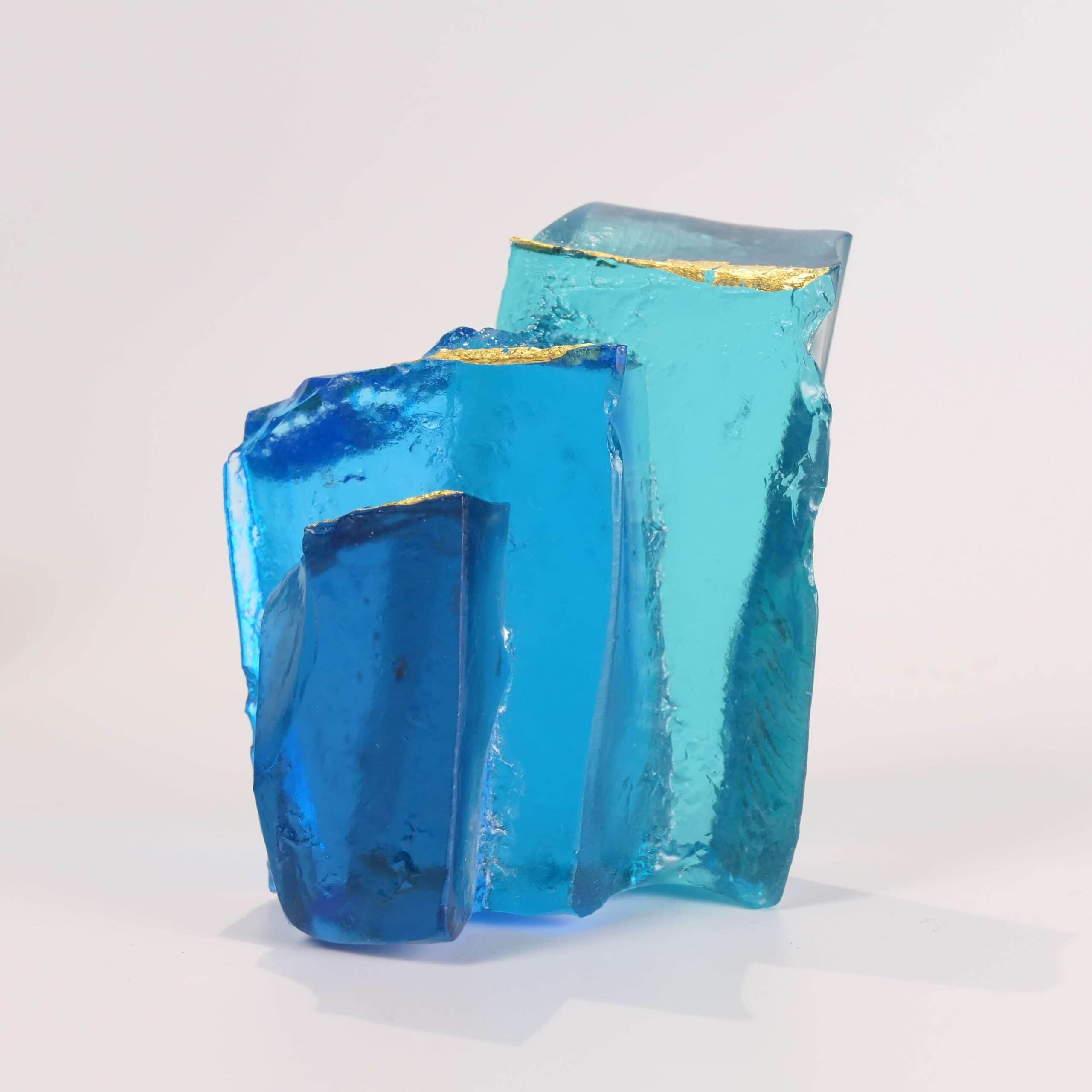 Handmade glass sculpture in the form of a fallen wall in light and dark blue with gold leaf