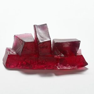 Red glass art sculpture with geometric blocks, modern design, and artistic craftsmanship.