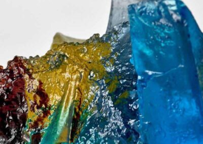 Brightly coloured glaa sculpture with blue, yellow, and red hues.