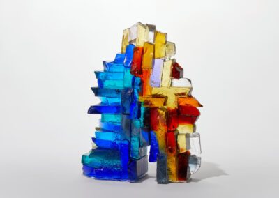 Colourful abstract glass sculpture by Deborah Timperley, showcasing vibrant blue, red, yellow, and c.