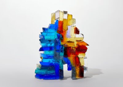 Colourful glass art sculpture with vibrant blue, yellow, red, and clear glass pieces.