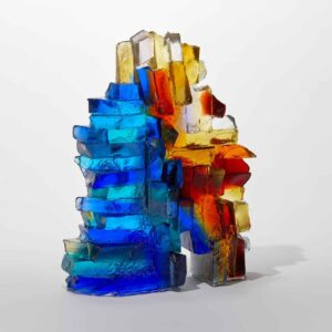 Vibrant glass sculpture with blue, red, and amber colours, showcasing modern art design.