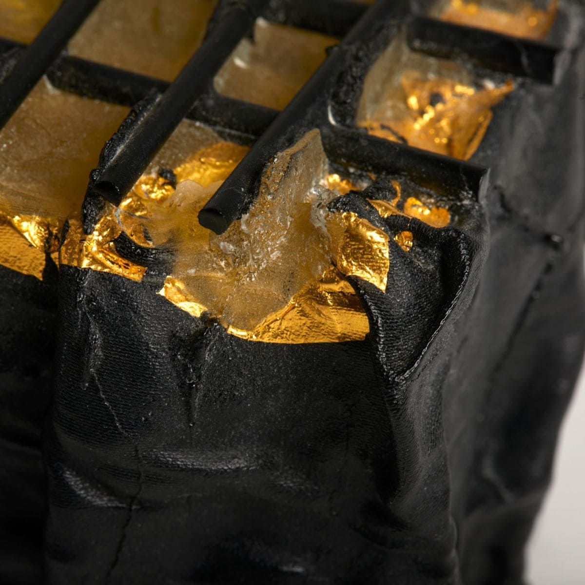 Gold leaf application on a glass sculpture project, highlighting luxury and artistic detail.